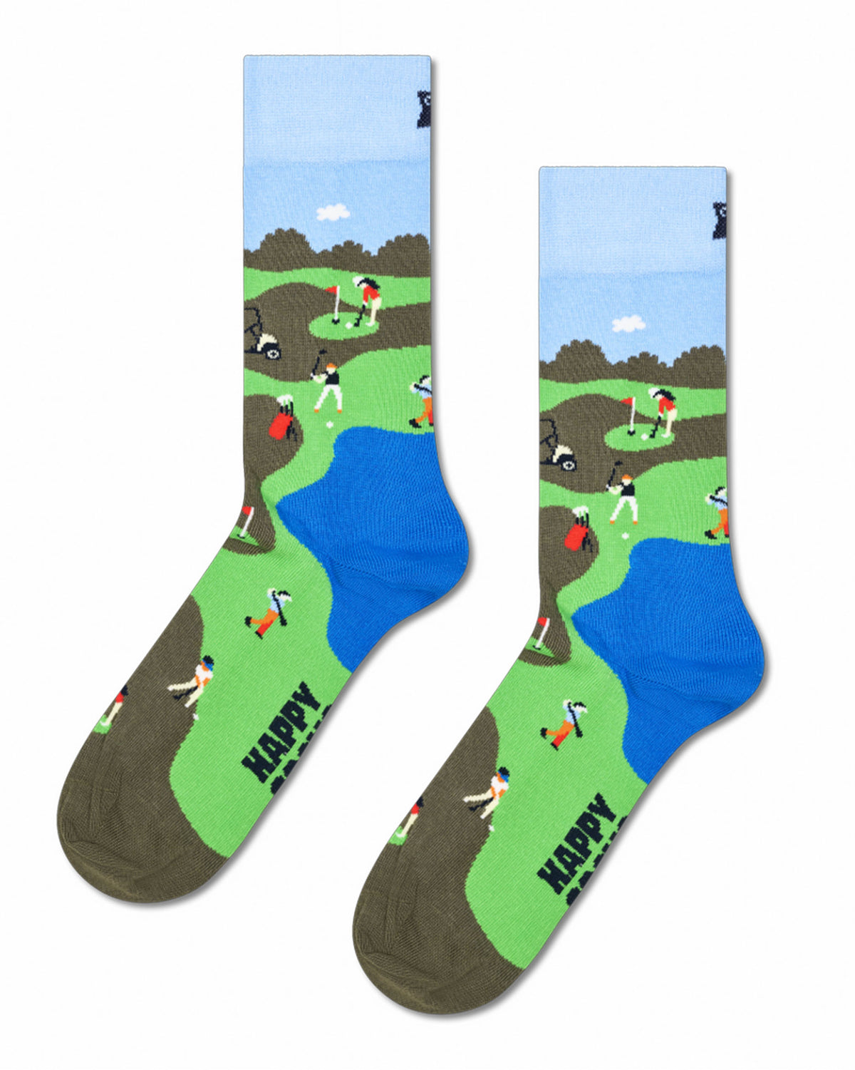 A pair of crew socks with a colorful golf course landscape print, featuring green grass, blue water, brown sand bunkers, and small illustrated golfers. The word 'HAPPY' is printed in black on the toes, and a small black logo is visible on the cuffs.