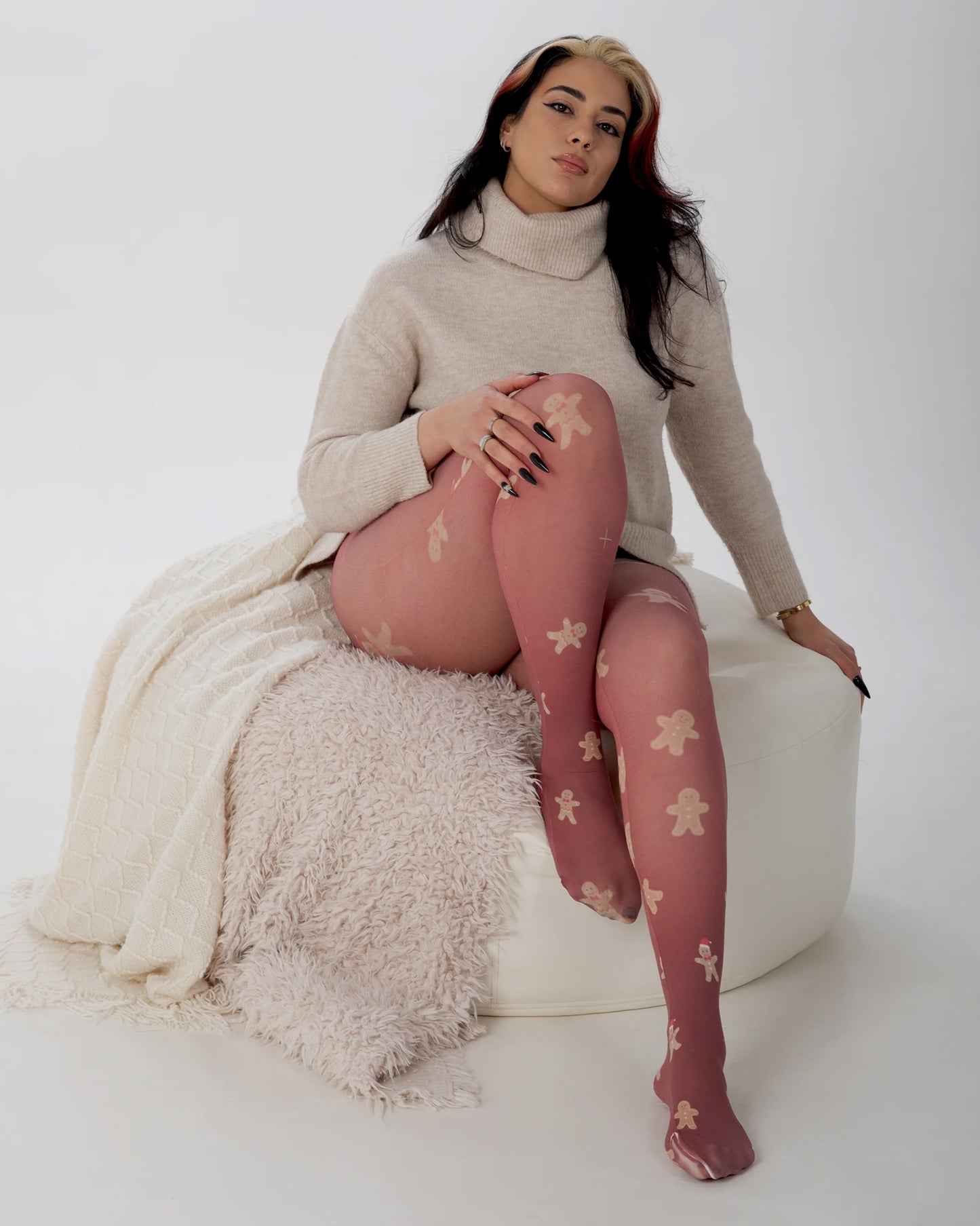 Pamela Mann Gingerbread Tights - White opaque fashion tights with an all over gingerbread man pattern with burgundy coloured background. Worn with a beige polo neck jumper.