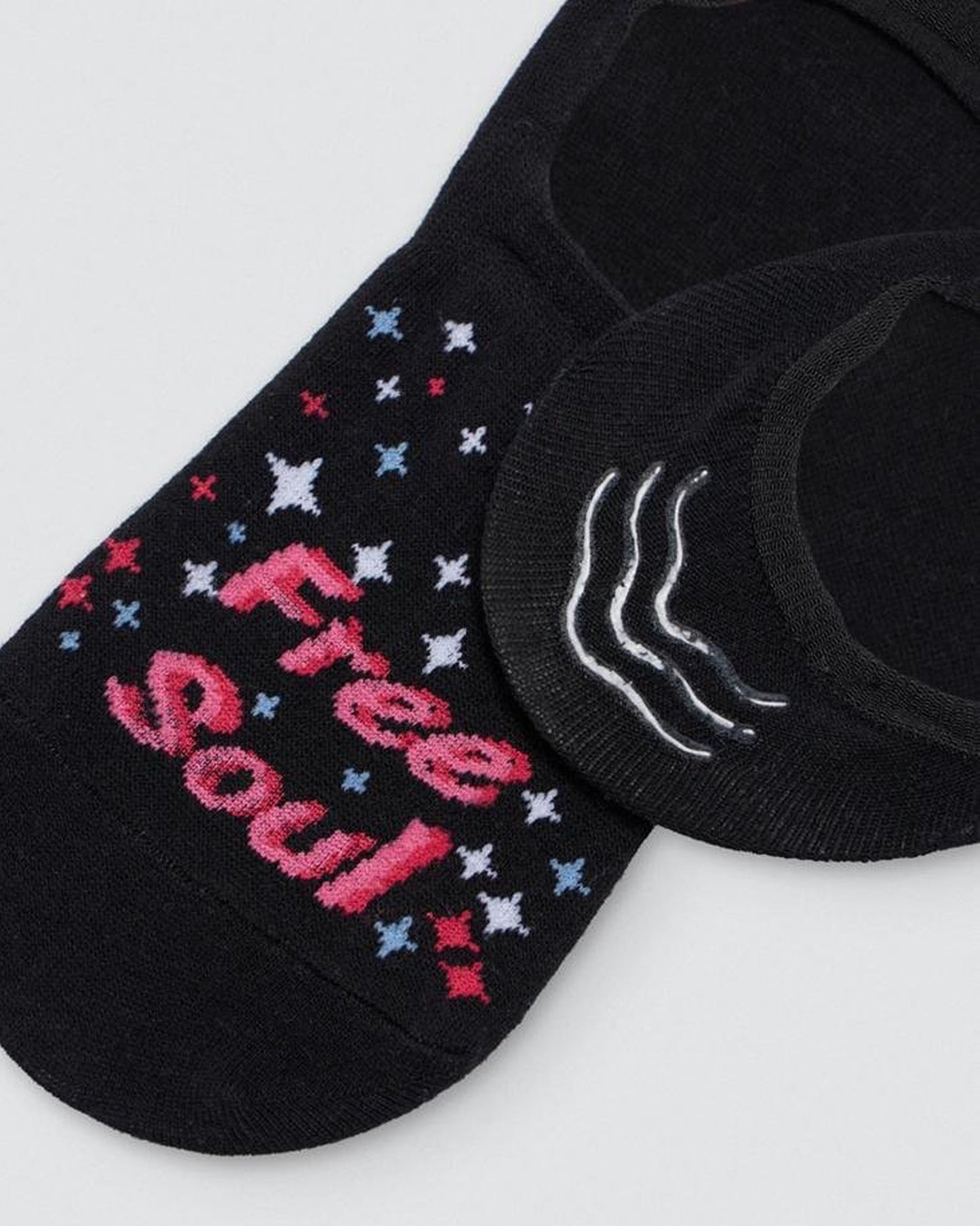 Ysabel Mora Free Soul Shoe Liner - Black cotton no show shoe liner sock with "Free Soul" and stars motif in shades of pink, blue & white and three stripes of silicone on the heel. Close up detail.