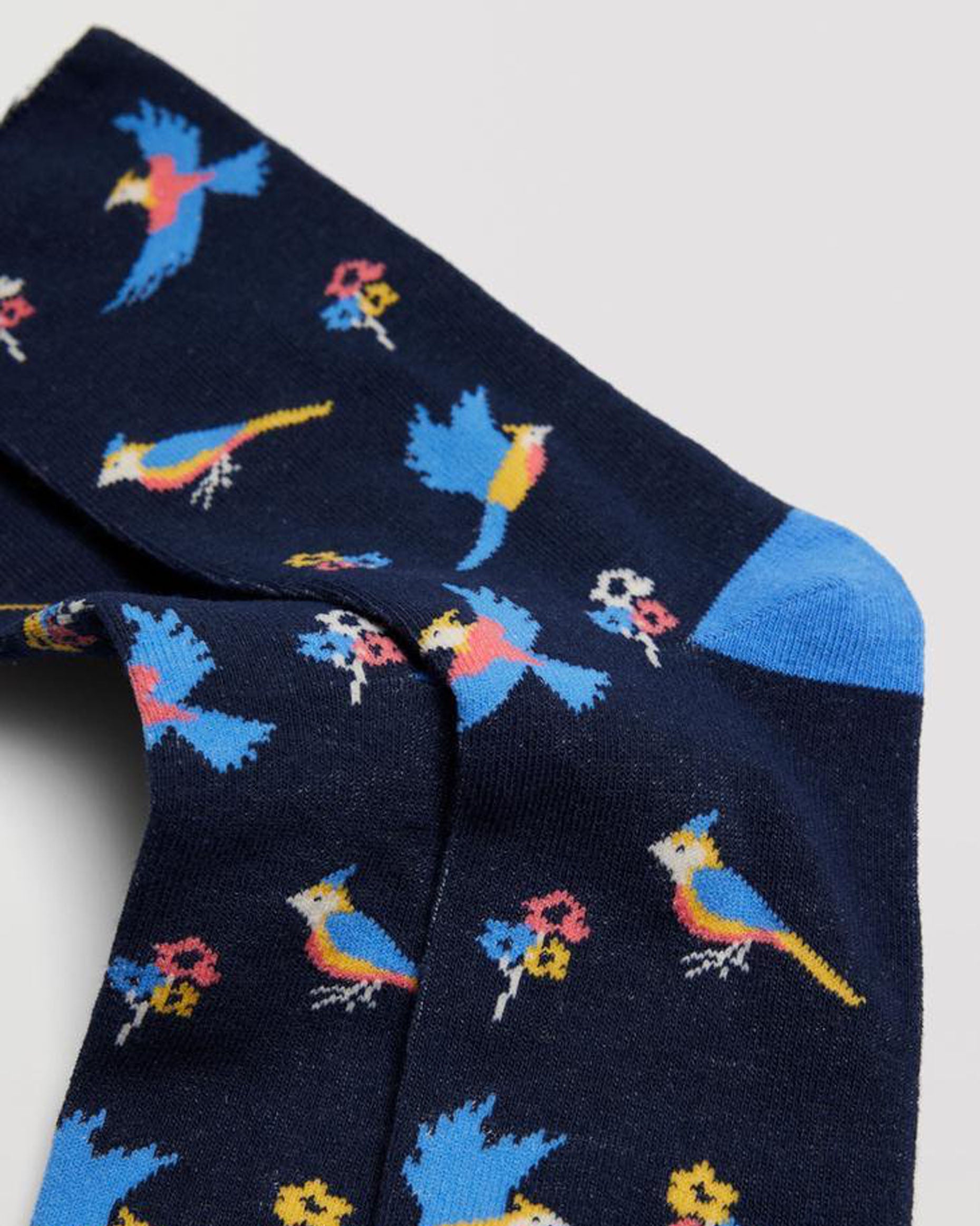 Ysabel Mora 12881 Bird Socks - Navy cotton socks with an all over multicoloured bird and flower pattern in sky blue, yellow, pale pink and white with a sky blue toe and heel and no cuff.