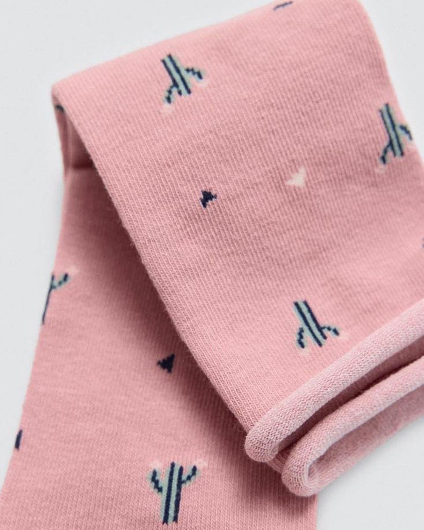 Pink socks with cactus patterns on a light grey background