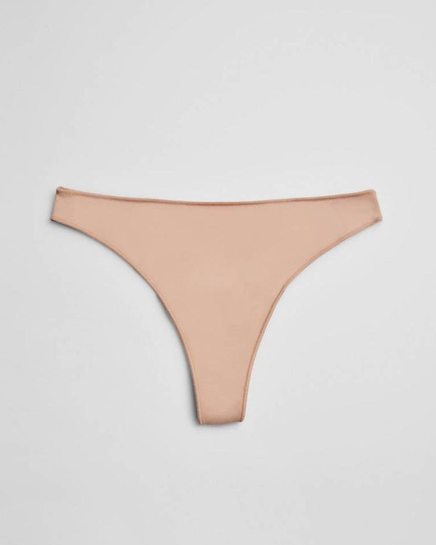 nude thong underwear on a light grey background
