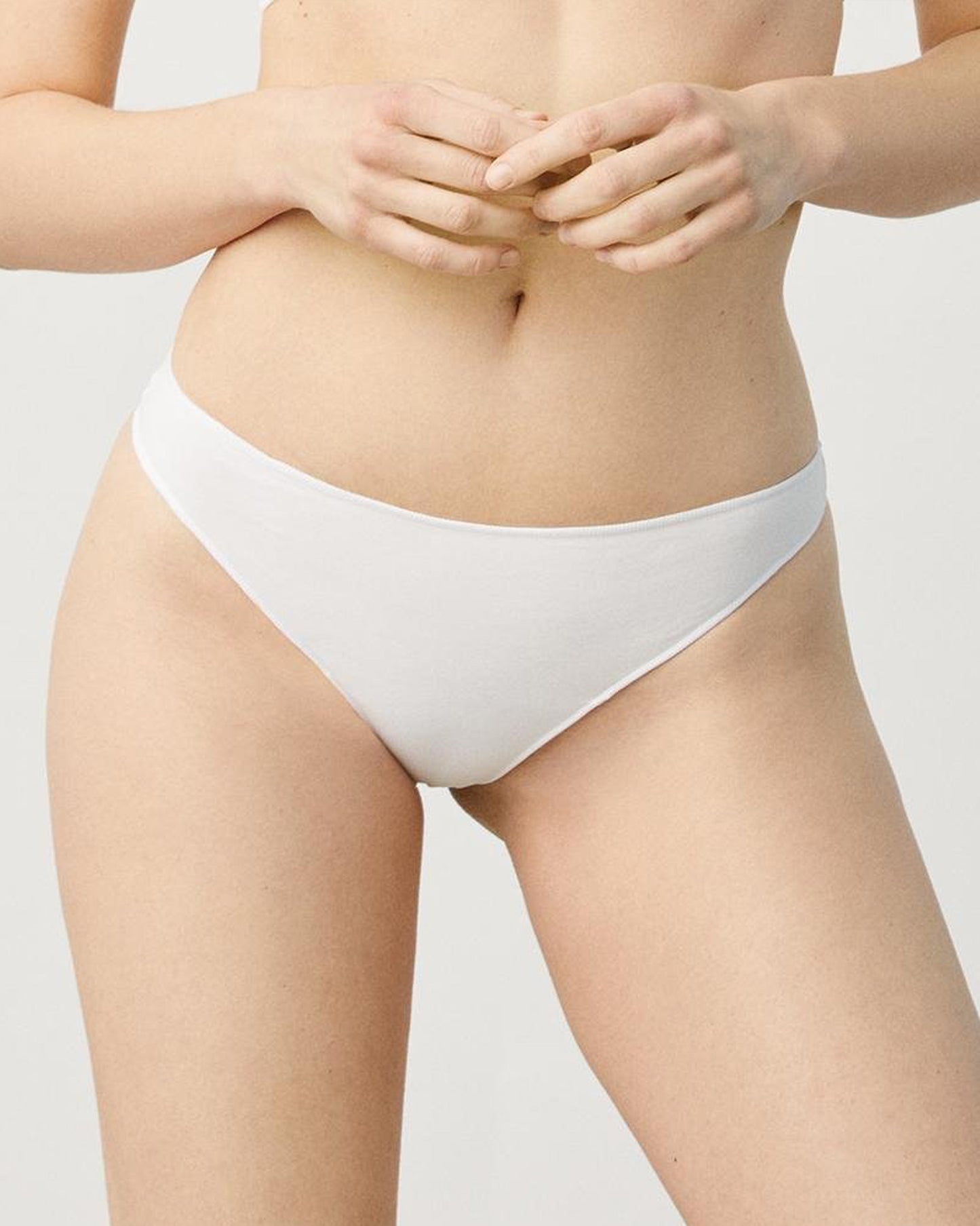 White Soft and comfortable low rise thong made with anti-allergic cotton.
High adaptability with elastane, this thong is slim with hand re-meshed non-marking seams. Front view.