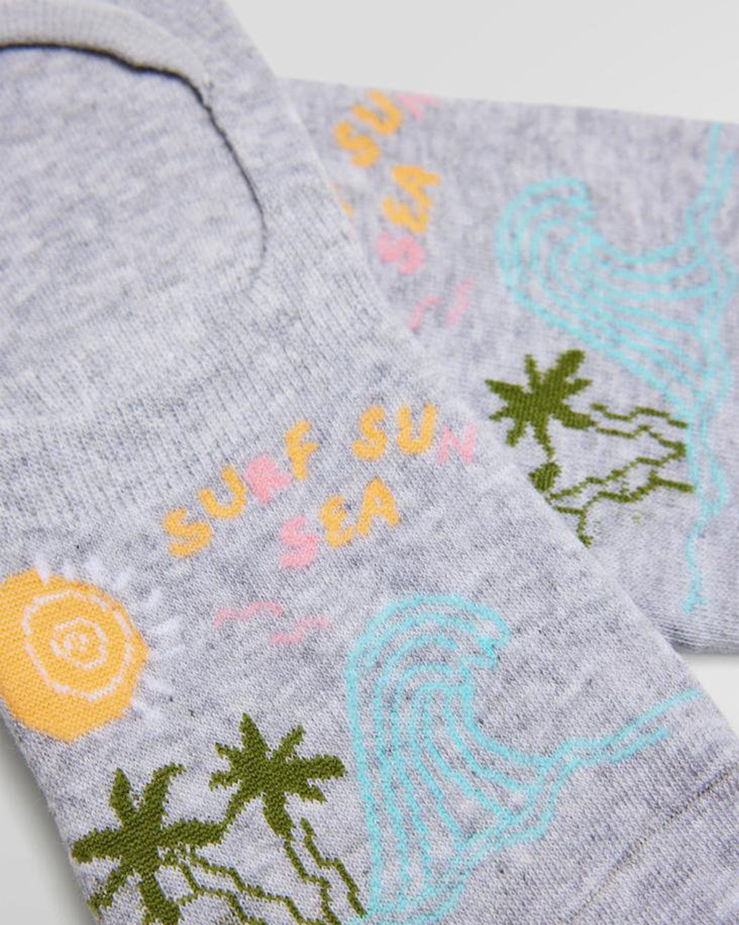 Ysabel Mora 12857 Surf Sun liners - Light fleck grey cotton no show sneaker socks with blue waves, green palm trees and sun design featuring the words "surf sun sea" in yellow and pink. The heel has an anti-slip silicone grip.