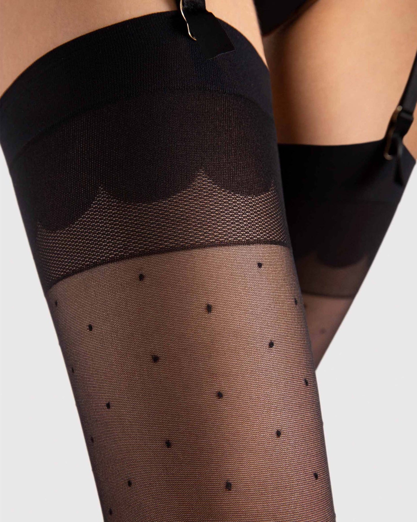 Fiore Marion 20 Den Stockings - Sheer black fashion stockings with a small woven spot pattern, plain deep top with a scalloped design detail. Close up detail.