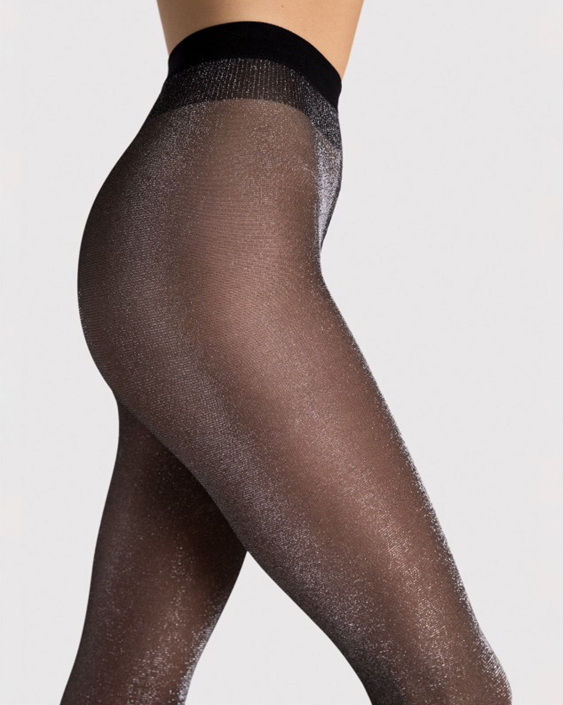 Black sheer tights with silver glitter worn by a person on a light grey background