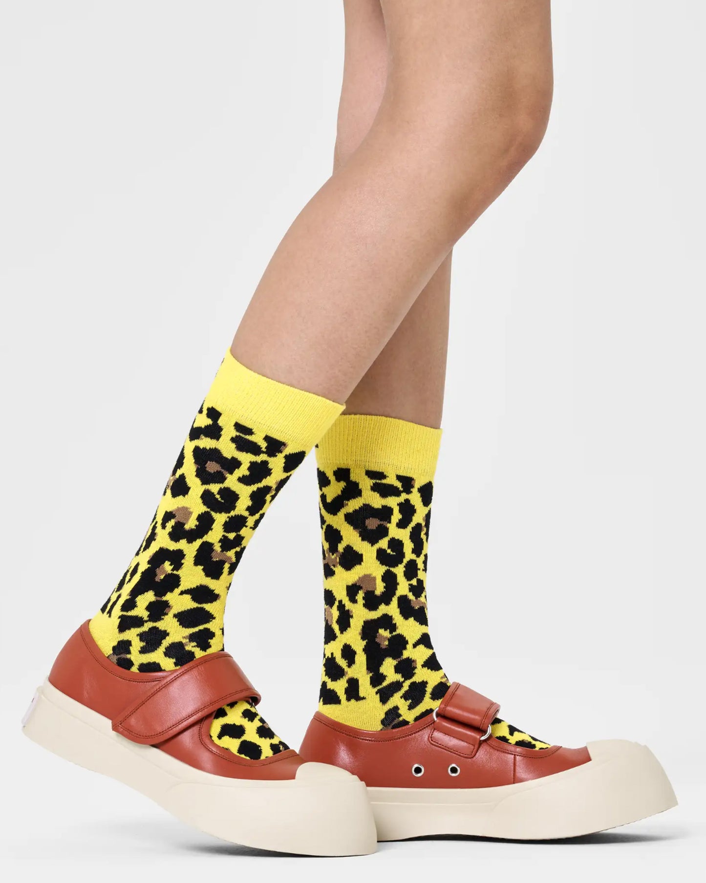 Happy Sock P000755 Leo Sock - Yellow cotton crew length ankle socks with a black and brown leopard print pattern. Worn with tan leather chunky shoes.