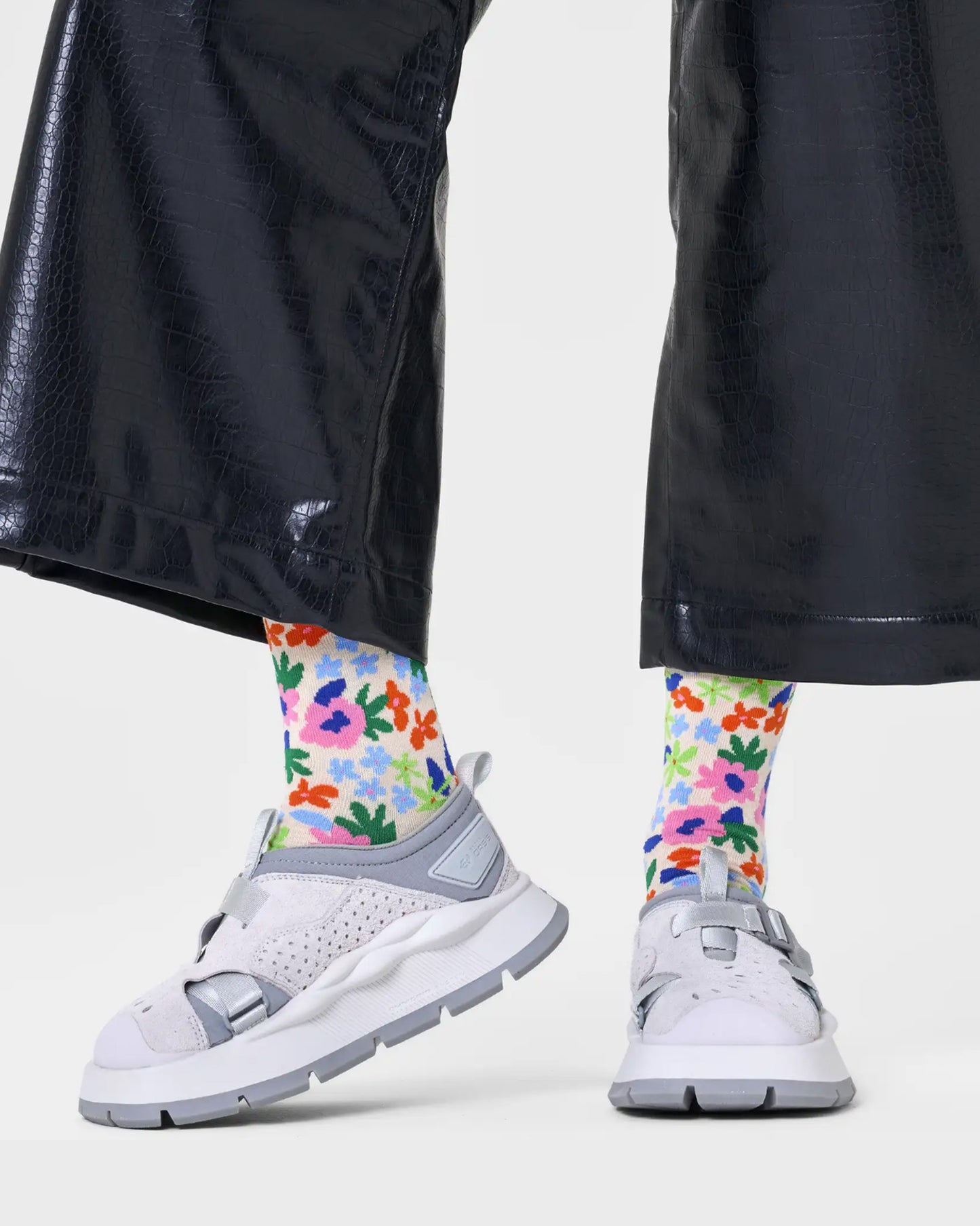 Happy Socks P000835 Flower Sock - Cream cotton crew length ankle socks with bright multicoloured flower pattern. Worn with dark navy faux crocodile skin pants and white and grey chunky trainers.