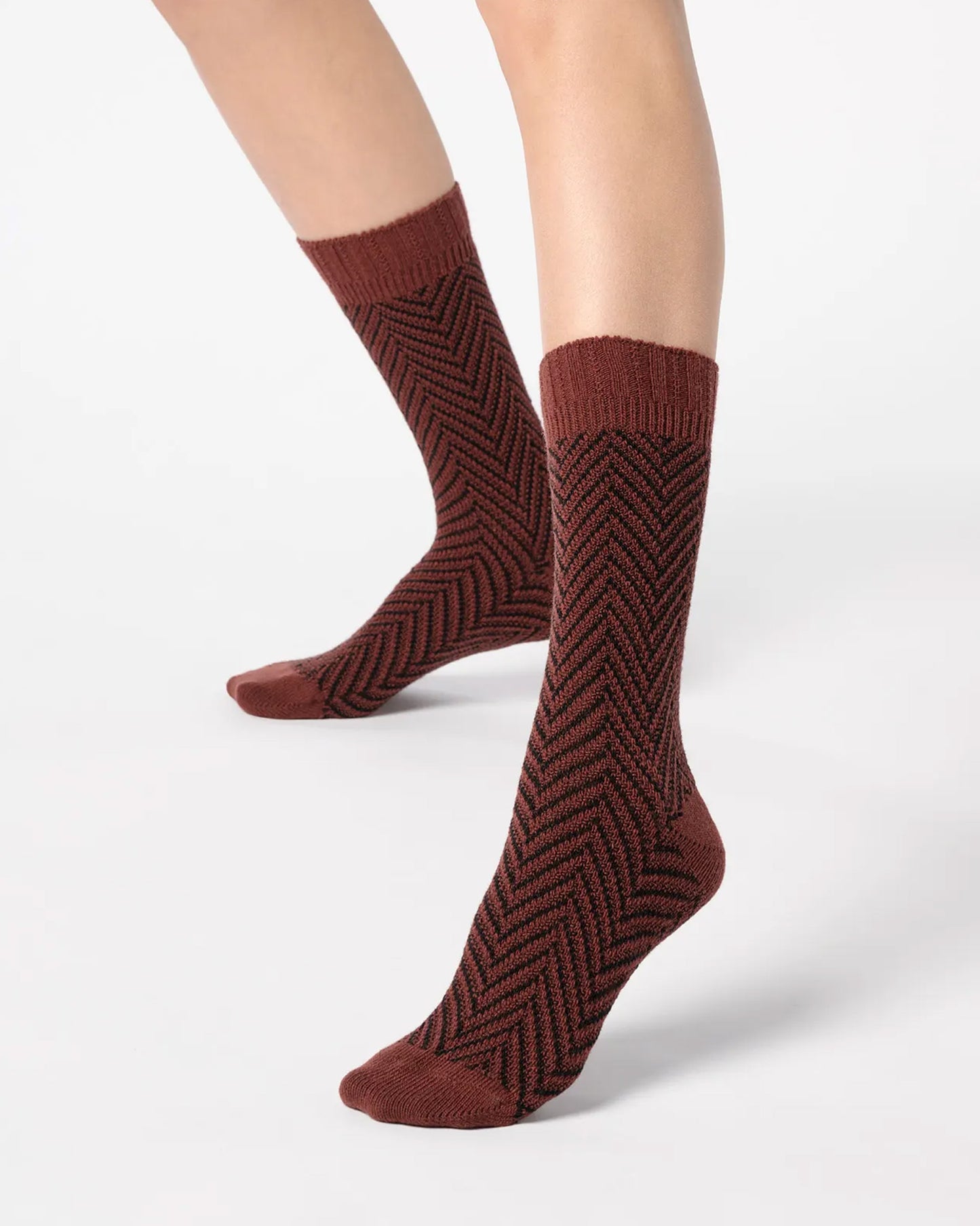 Brown red chunky knitted socks with a black zig-zag pattern