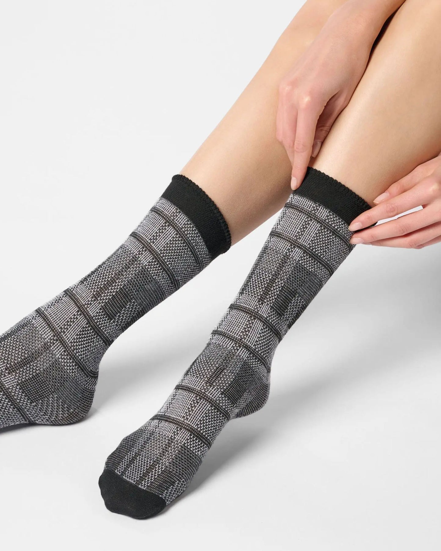 Light grey ankle socks with a large tartan pattern, black toe and cuff.