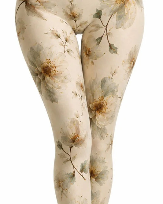 Close-up of a person's legs wearing cream tights with a large floral print in muted grey-green and warm tan tones, shown against a plain white background.