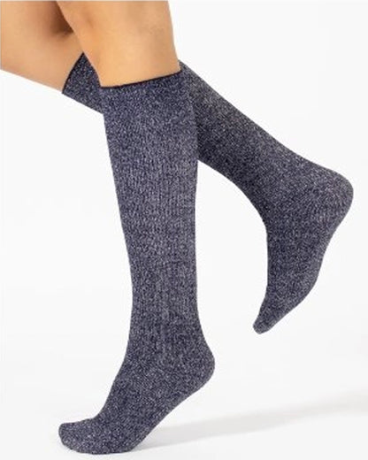A pair of sparkly navy blue knee-high socks worn on a model's legs, shown against a plain white background.