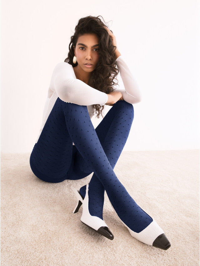 Fiore Dry Pastel Tights - Glossy navy opaque fashion tights with an all over light honeycomb and spot pattern in black, worn with white long sleeved top and white and black heel shoes.