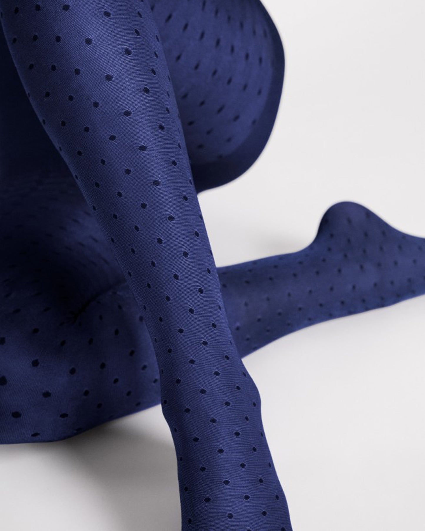 Fiore Dry Pastel Tights - Close up of a glossy navy opaque fashion tights with an all over light honeycomb and spot pattern in black.