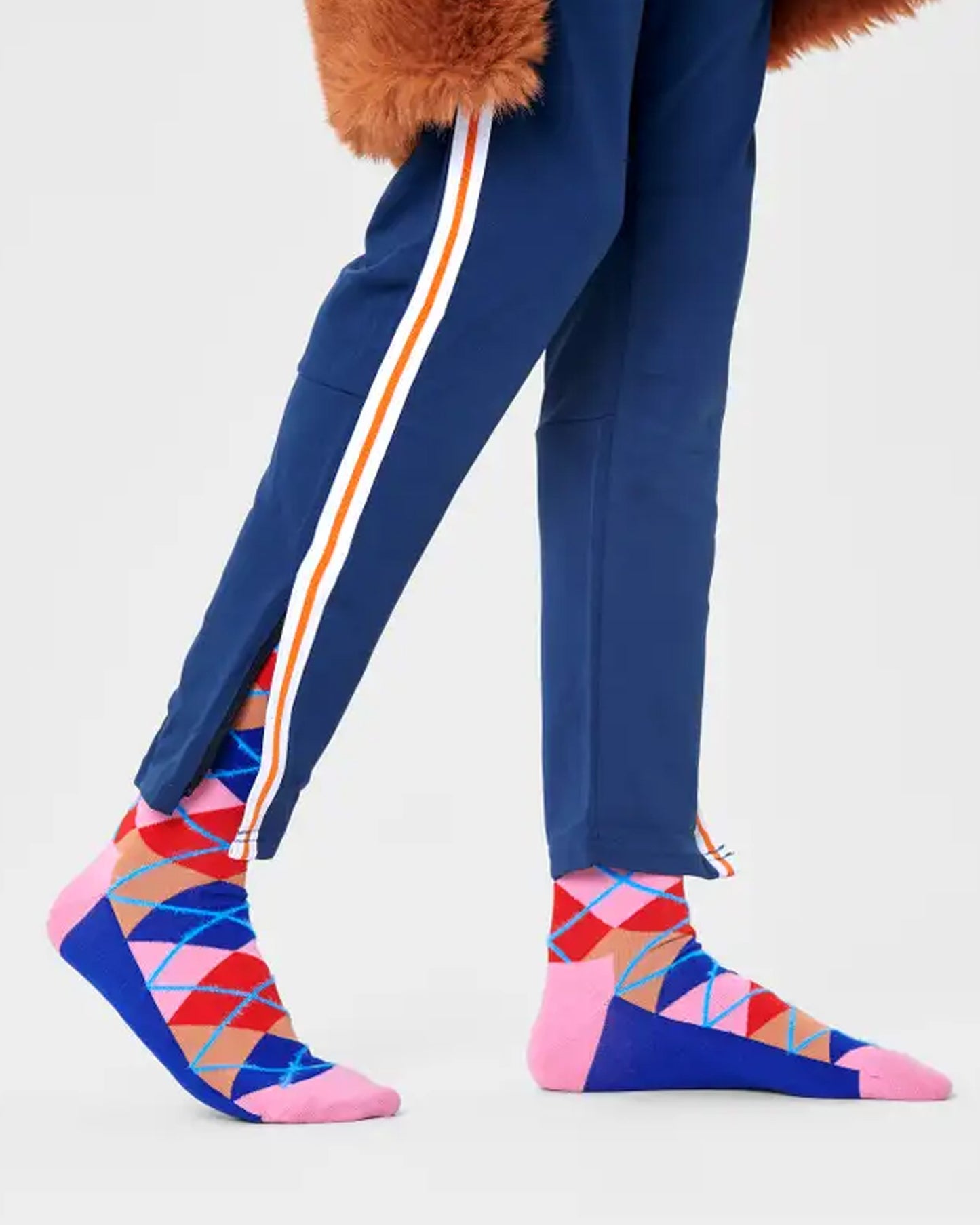 Happy Socks ARY01-8300 Argyle Sock - Cotton crew length ankle socks with a diamond argyle style pattern in royal blue, light pink, red and beige with a stripe of fluffy light blue, worn with sporty stripe pants and faux fur coat.