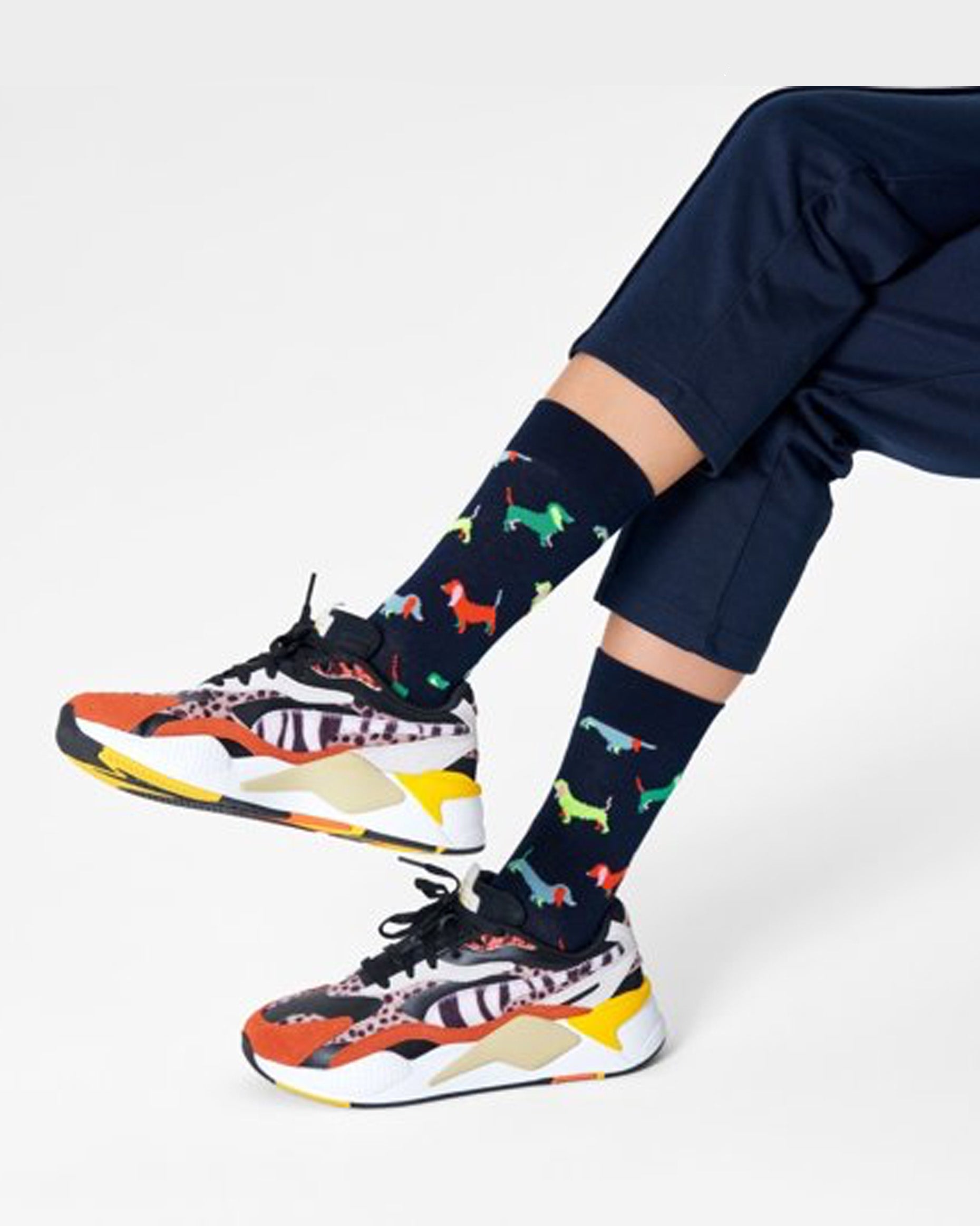 Happy Socks PUL01-6500 Puppy Love Sock - Dark navy cotton crew length ankle socks with a multicoloured dachshund type pattern. Worn with colourful chunky trainers and navy cropped pants.