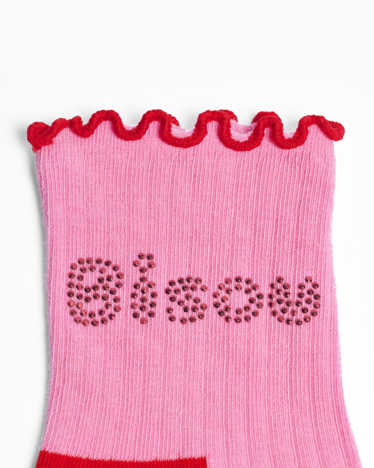 Pink ribbed sock with red frill trim and 'bisou' text on a white background