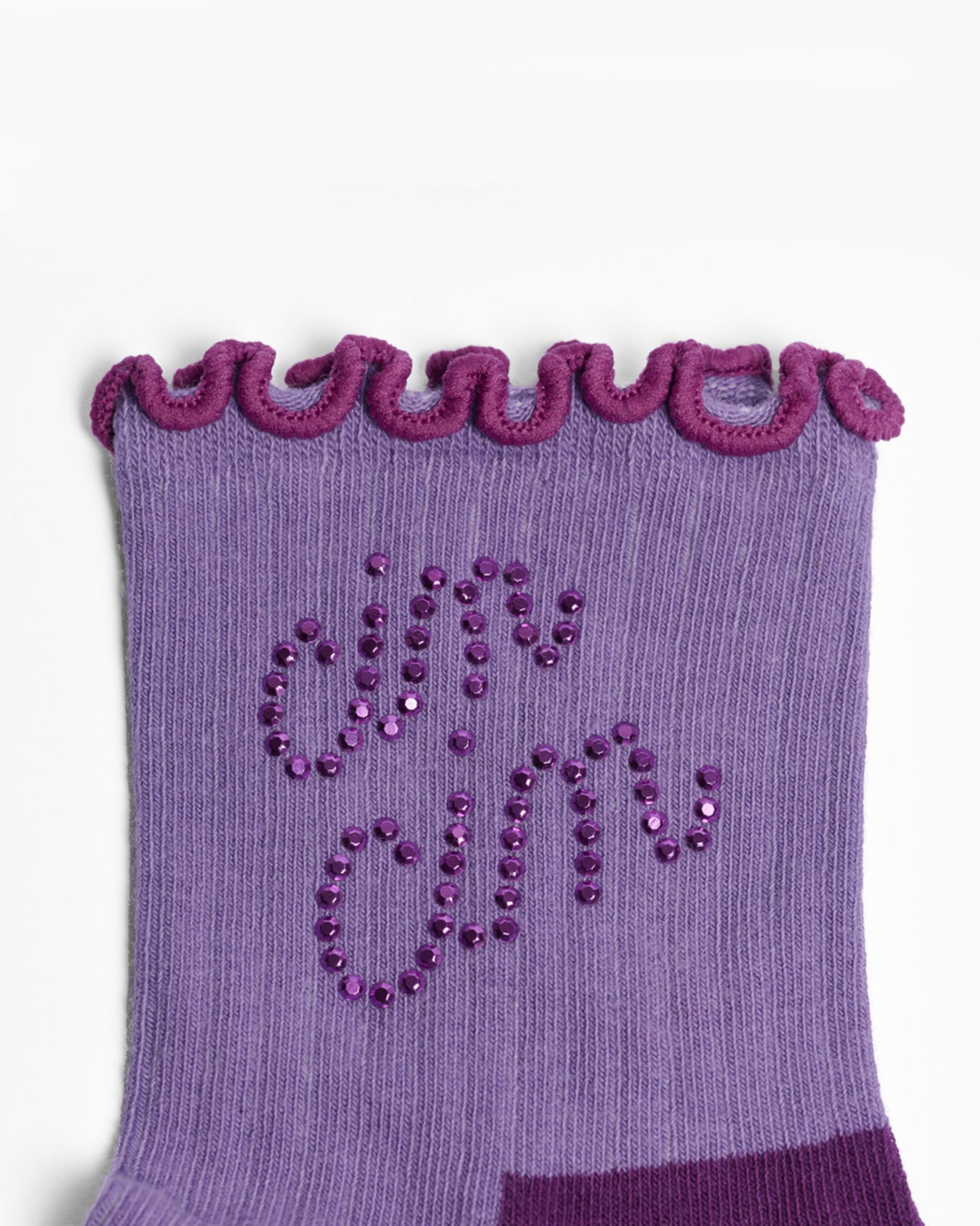 Purple sock with decorative trim and 'cin cin' text on a white background