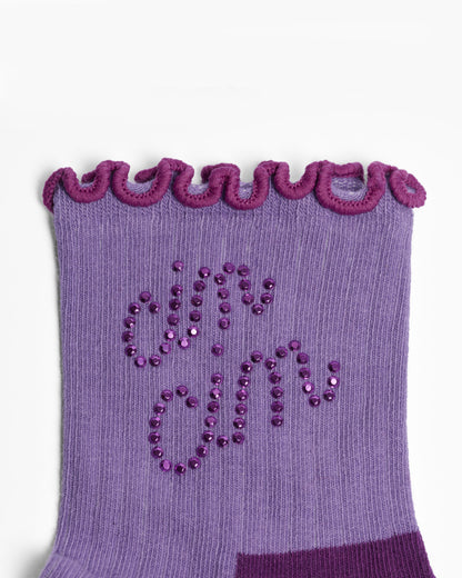 Purple sock with decorative trim and 'cin cin' text on a white background