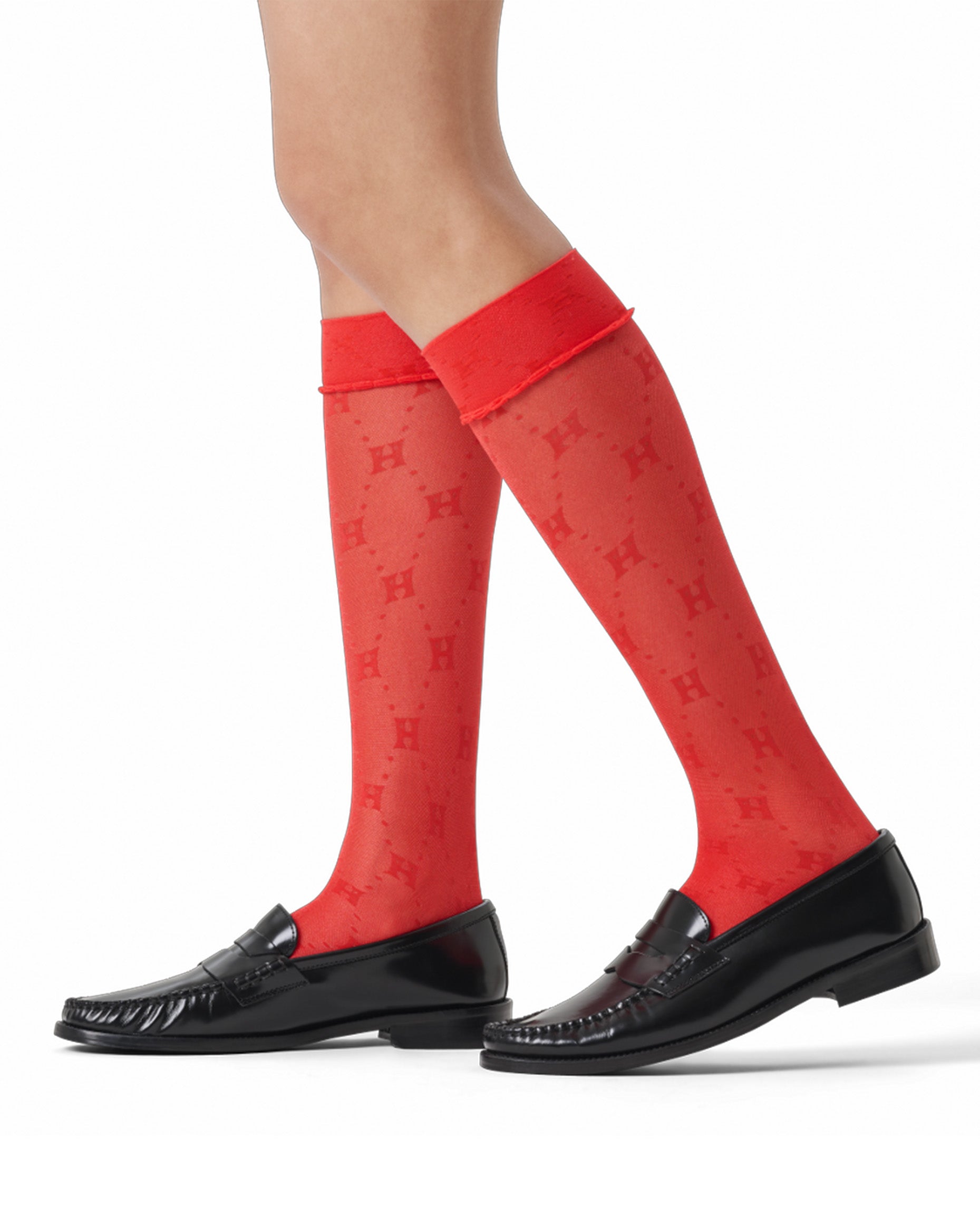Red knee-high socks with a pattern worn by a person on a white background