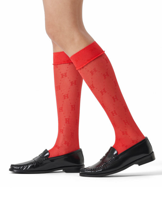 Red knee-high socks with a pattern worn by a person on a white background