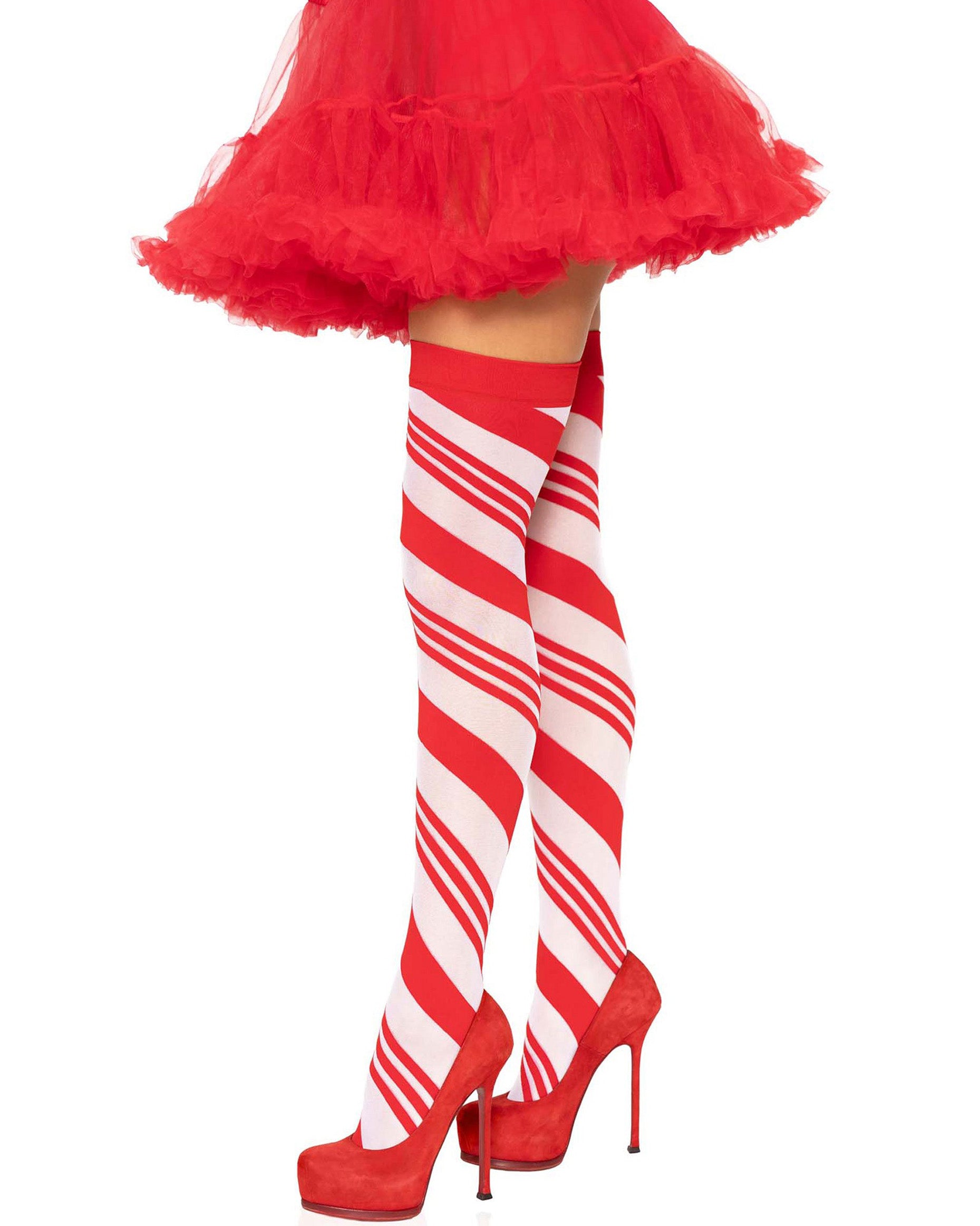 Leg Avenue 6628 Candy Cane Stockings - White opaque thigh high socks with a swirling candy cane style stripe wrapping diagonal around the leg with a plain red elasticated cuff. Worn with red high heel stilettos and red frilly tulle petticoat.