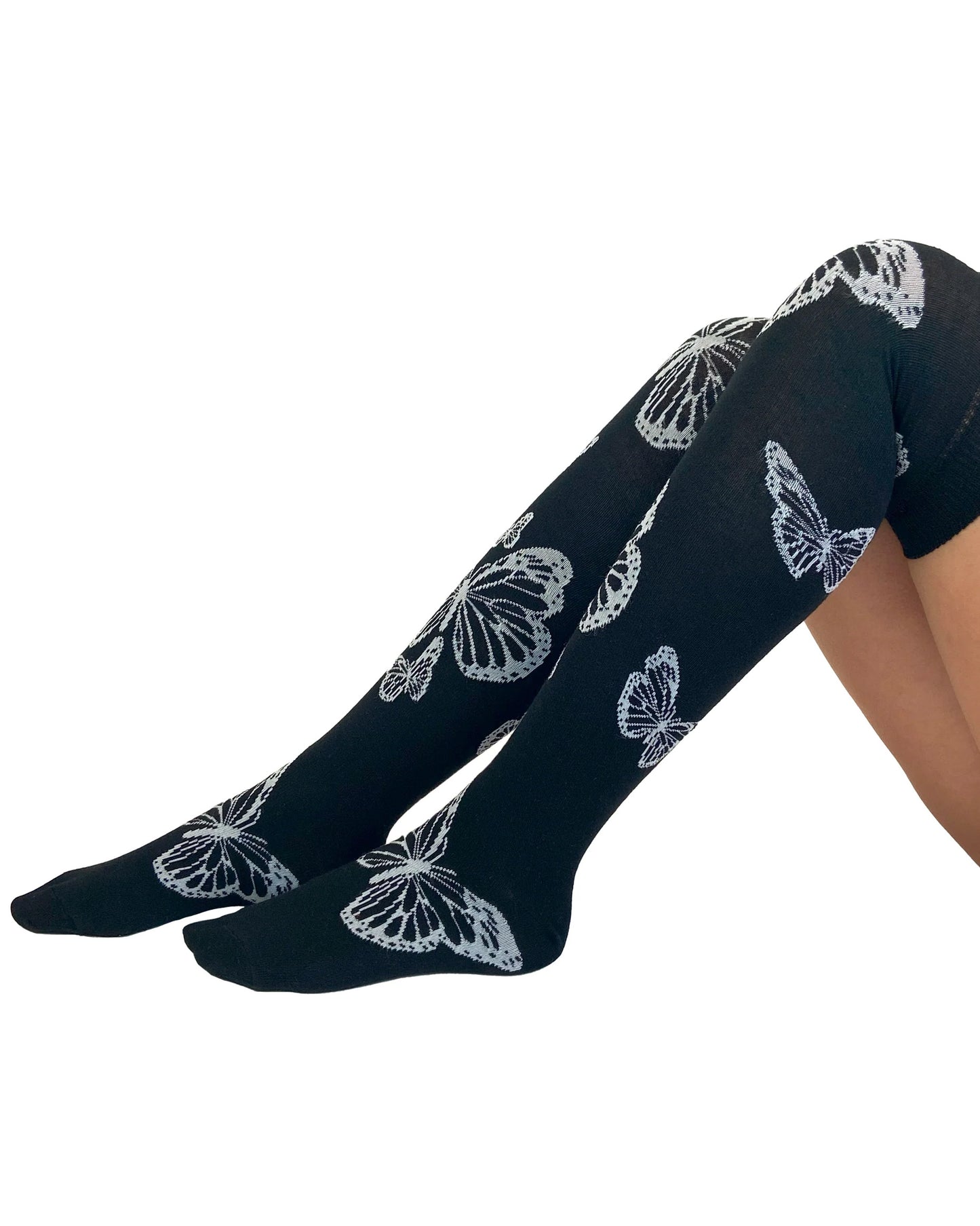 Soft cotton mix black knitted over-knee socks with white butterfly motif pattern that flutters up the leg and deep elasticated cuff.