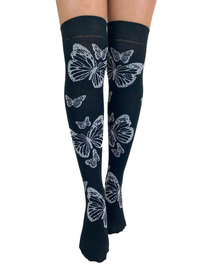 Soft cotton mix black knitted over-knee socks with white butterfly motif pattern that flutters up the leg and deep elasticated cuff. Front view.