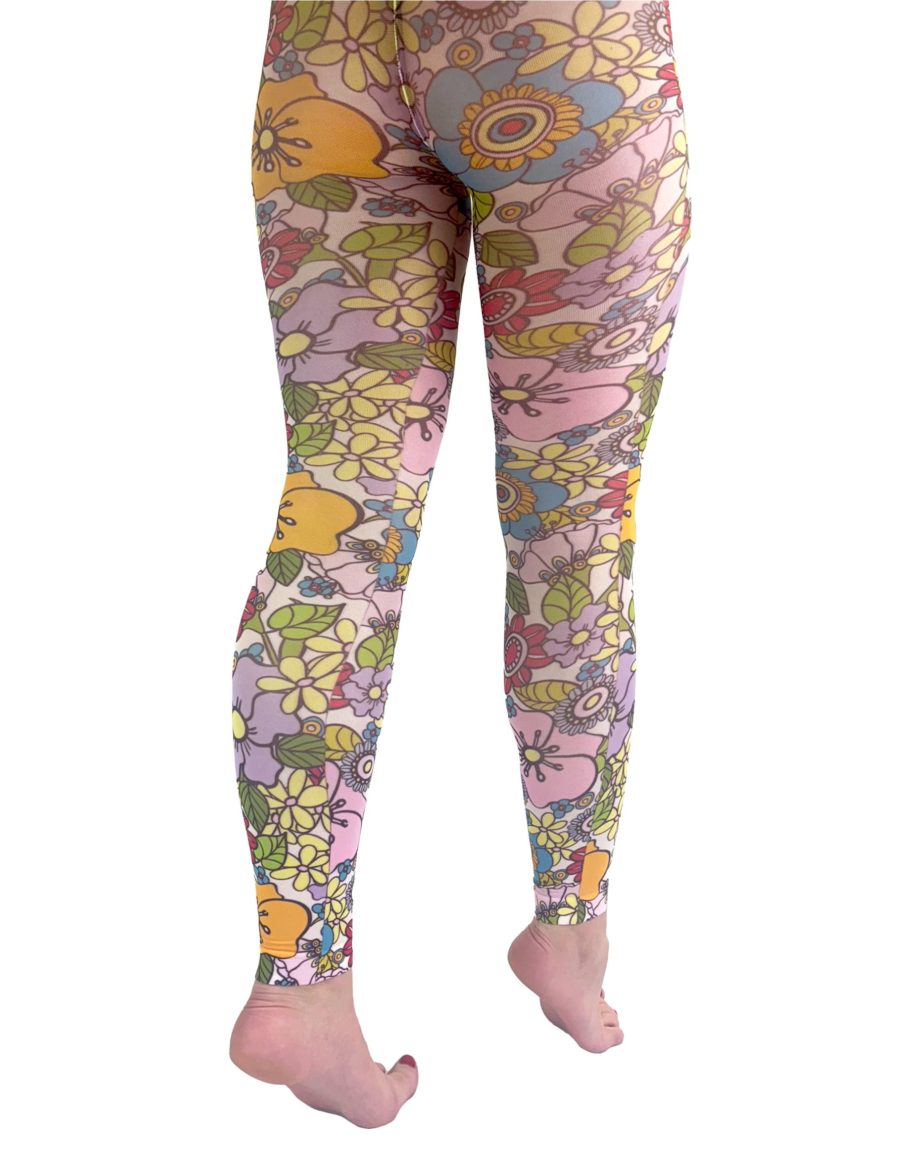 Pamela Mann Flower Power Footless Tights - Pale pink opaque footless tights with a sixties style flower print pattern in bright shades of purple, yellow, blue, red, pink, orange and outlined in black. Back view.