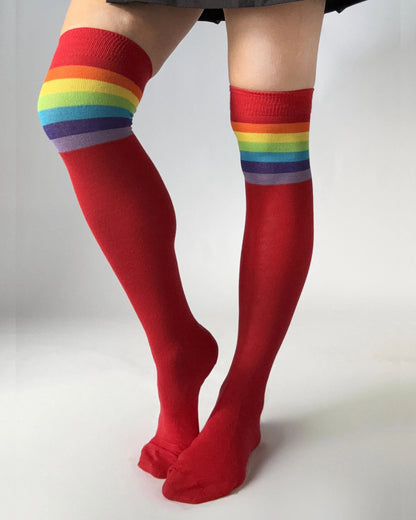 Red over-knee socks with a colourful rainbow striped cuff.