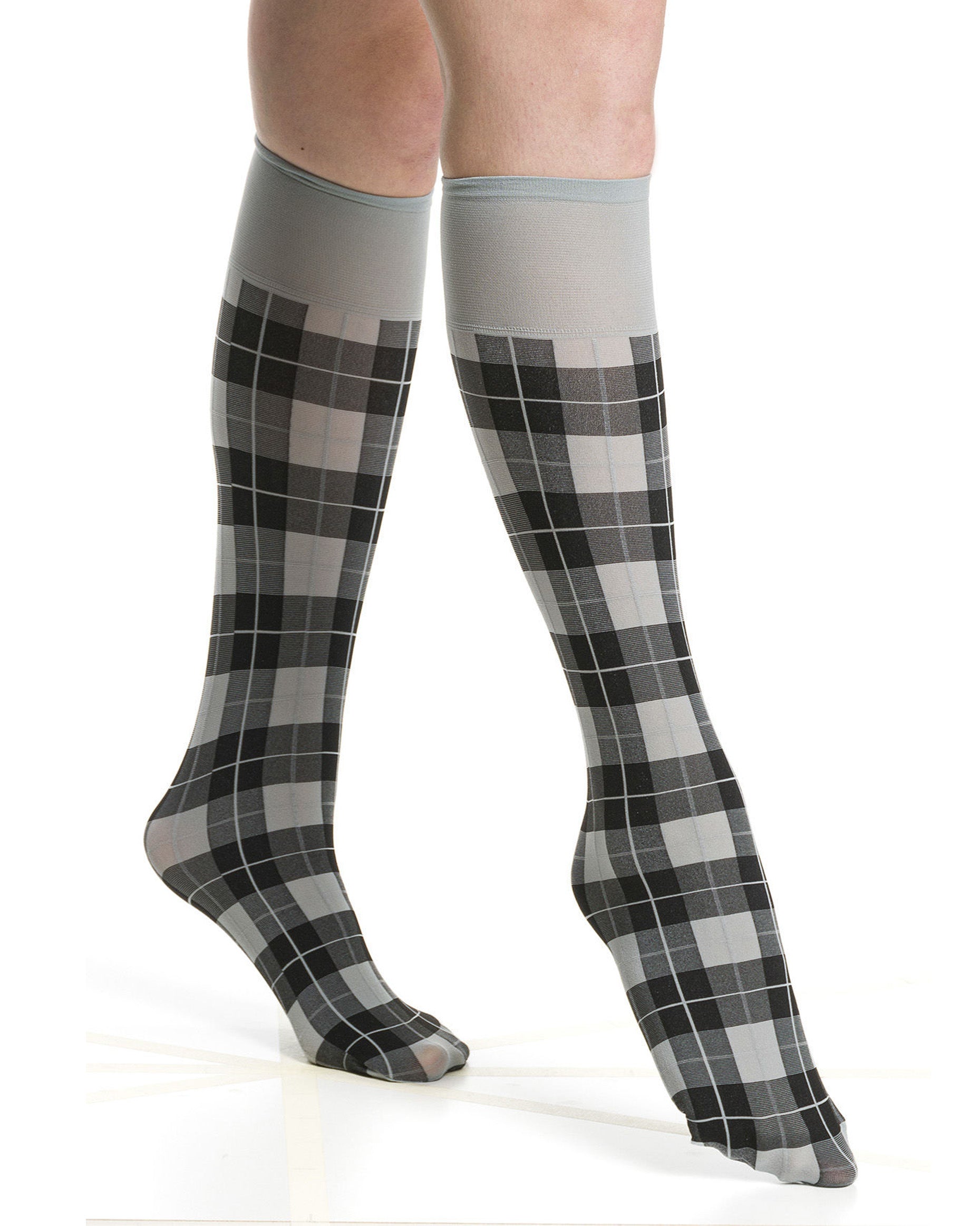 Light grey and black plaid tartan knee-high socks worn by a person on a white background