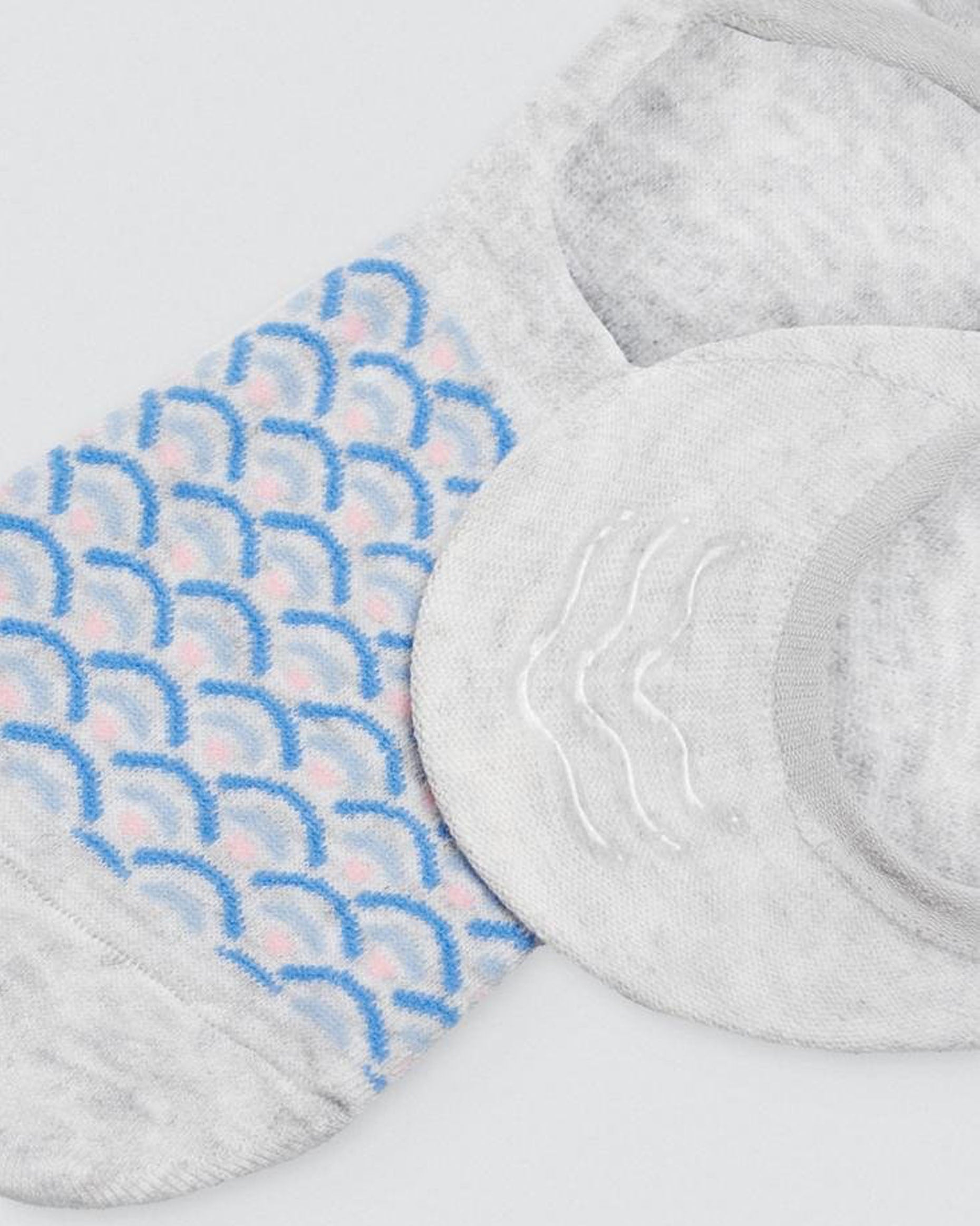 Ysabel Mora Fish Scale Shoe Liners - Light fleck grey no show shoe liner socks with a blue and light pink fish scale style pattern and three strips of silicone on the heel. Close up detail.