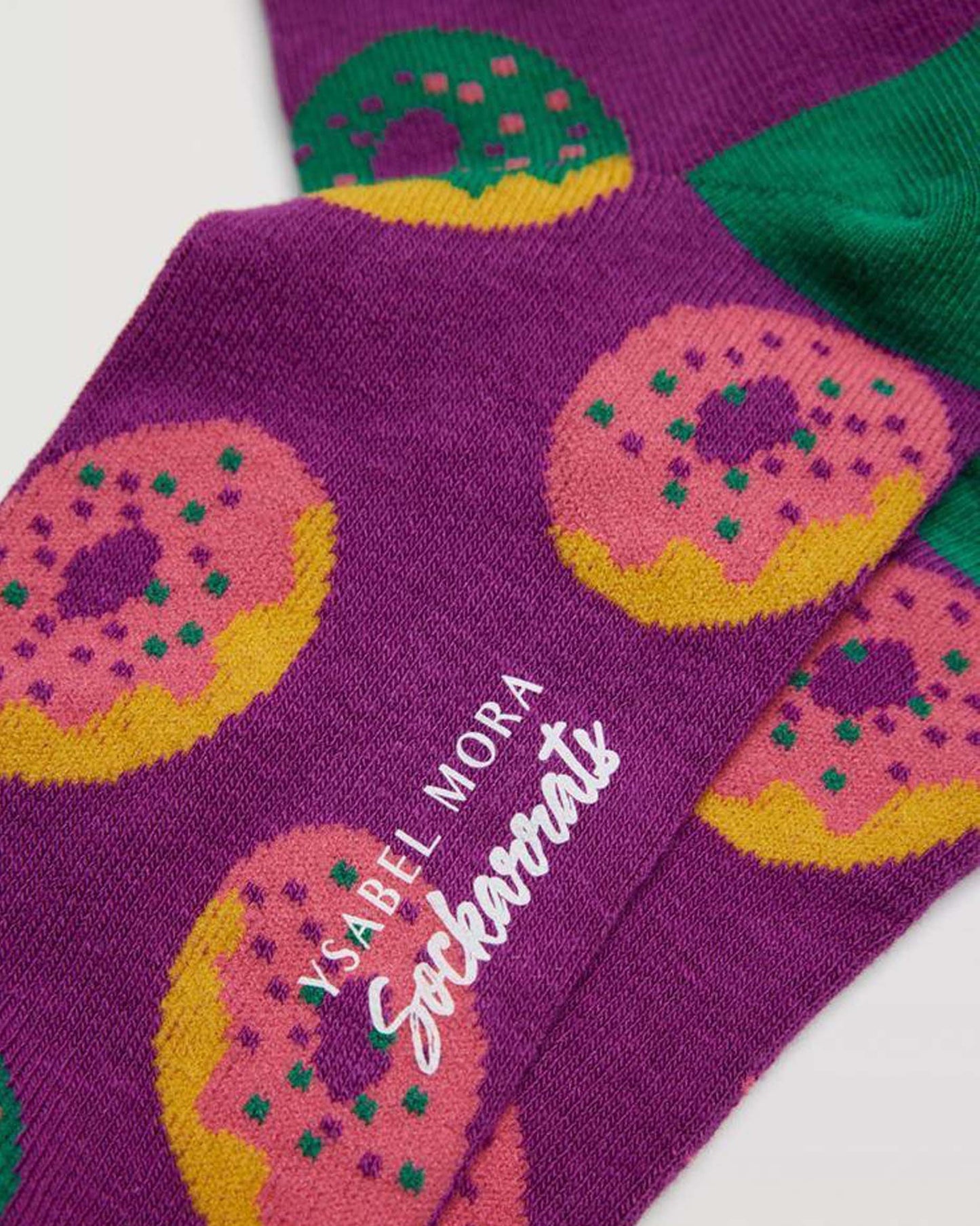 Ysabel Mora Sockarrats - Purple cotton socks with an all over pattern of ring donuts with sprinkles in green, pink and mustard and green heel.