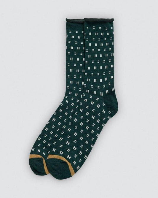 Green sock with white pattern on a light gray background