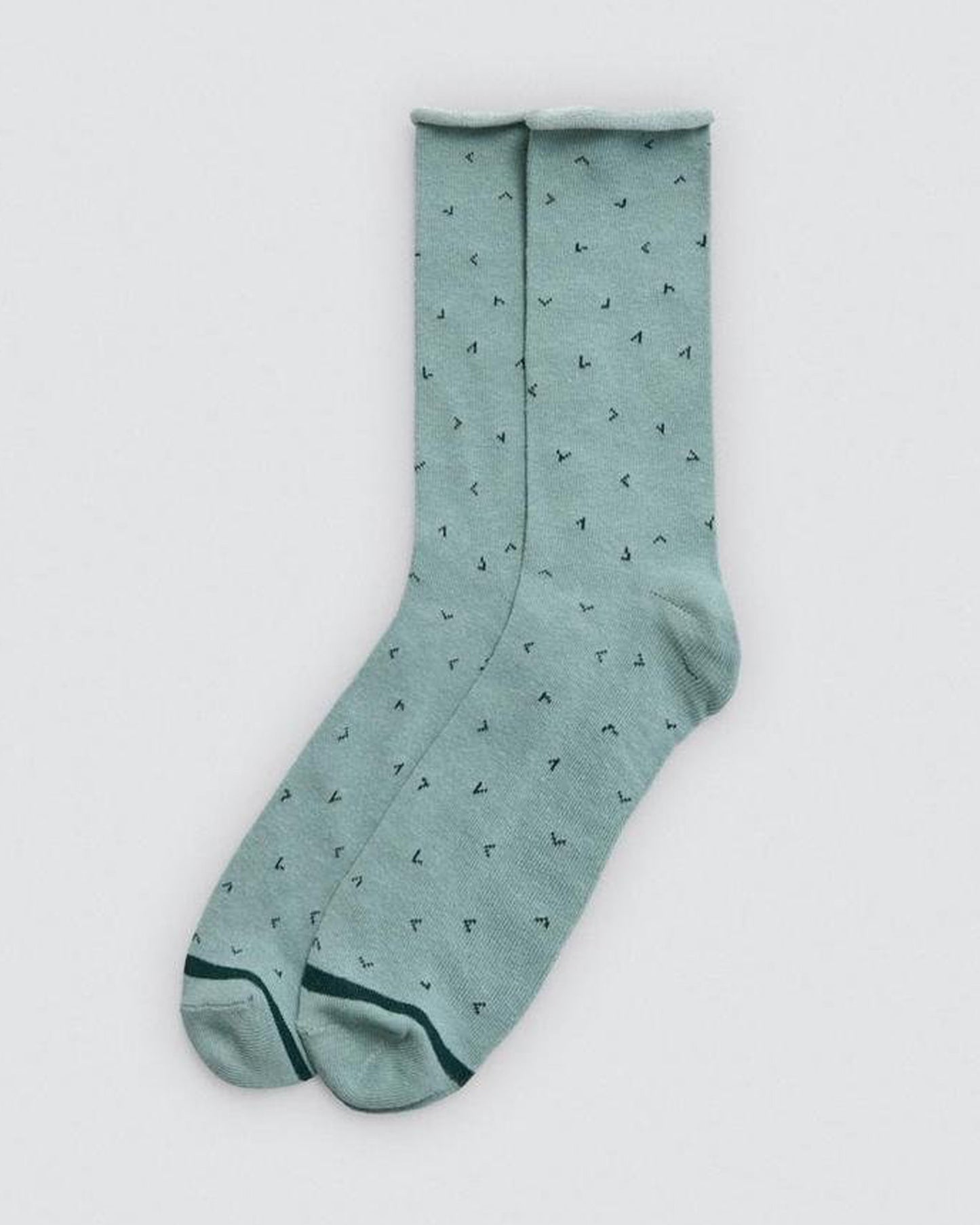 Pair of light mint green socks with small black patterns on a white background