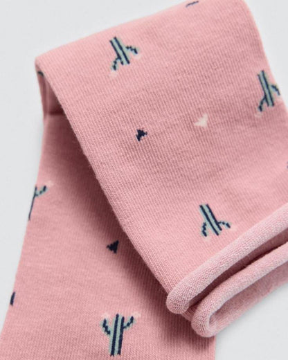 Pink socks with cactus patterns on a light grey background