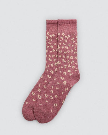 Dirty pink wooly sock with beige leopard print pattern on a light gray background