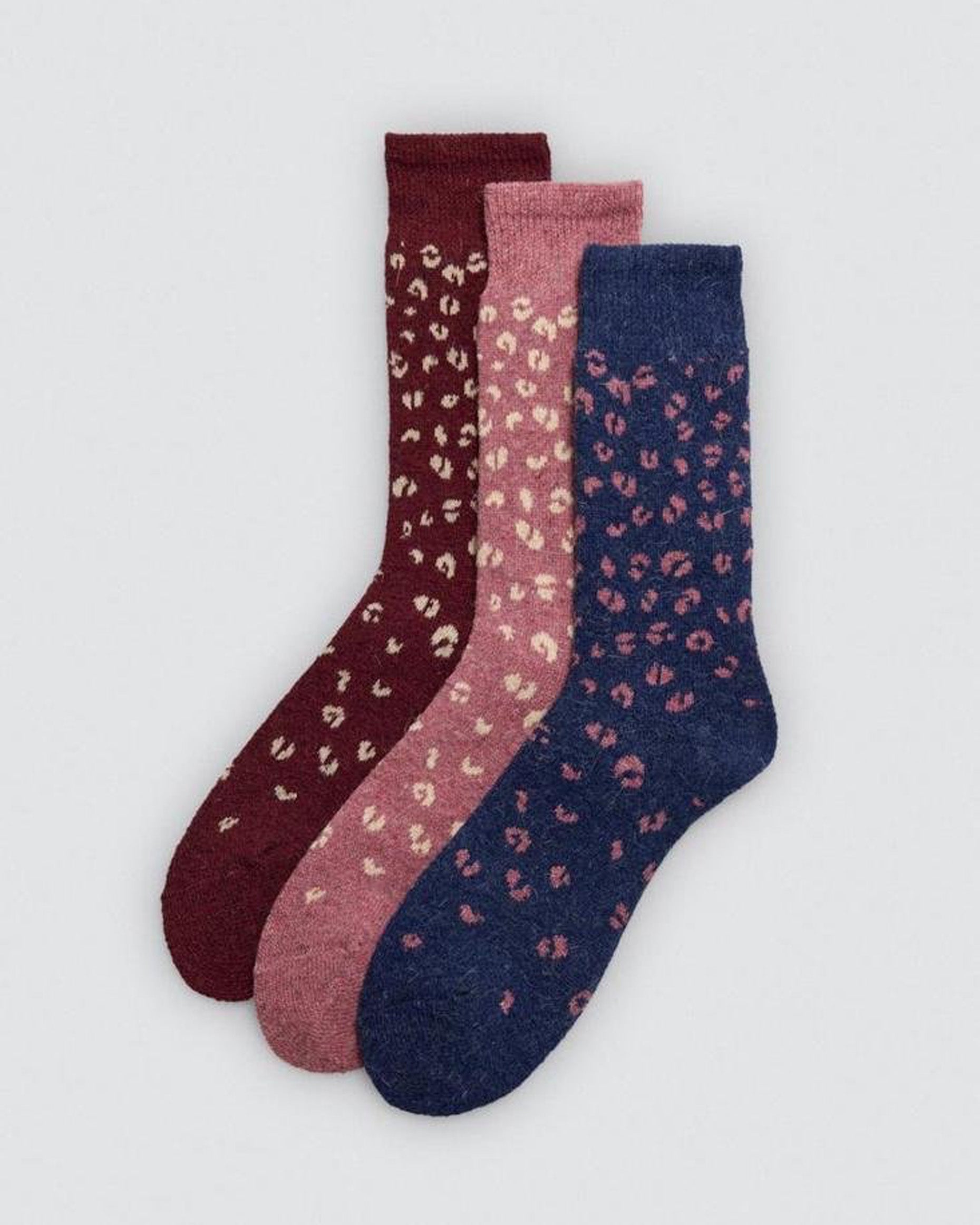 Three pairs of socks with leopard print pattern on a light gray background