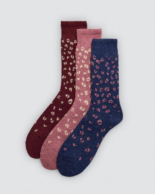 Three pairs of socks with leopard print pattern on a light gray background