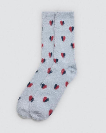 Pale blue fluffy sock with red and blue heart patterns on a light grey background