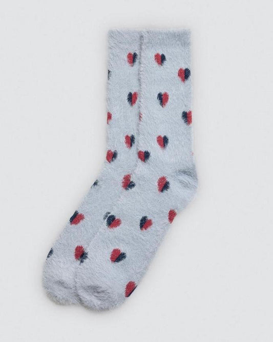 Pale blue fluffy sock with red and blue heart patterns on a light grey background
