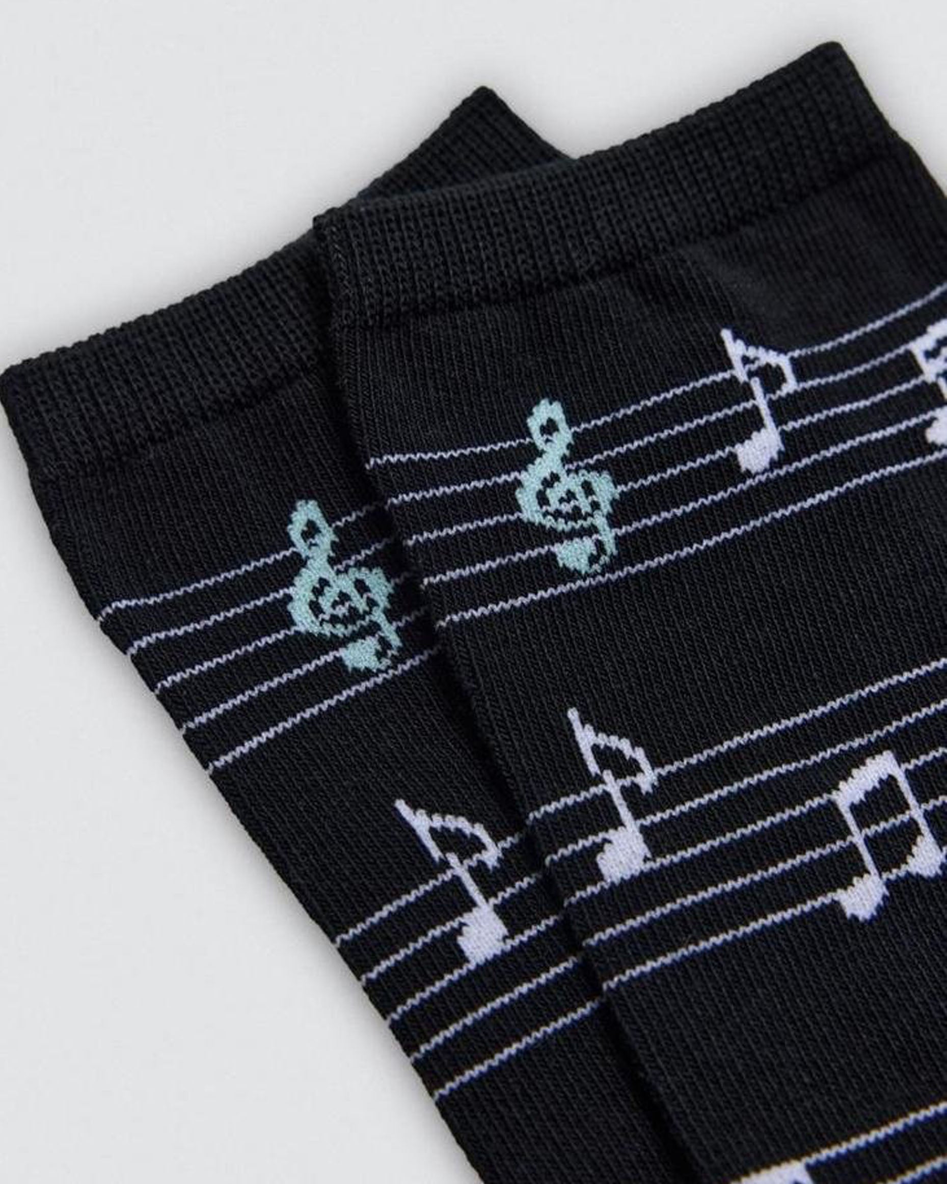 Black socks with musical note pattern on a light gray background