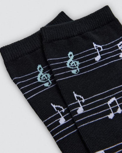Black socks with musical note pattern on a light gray background