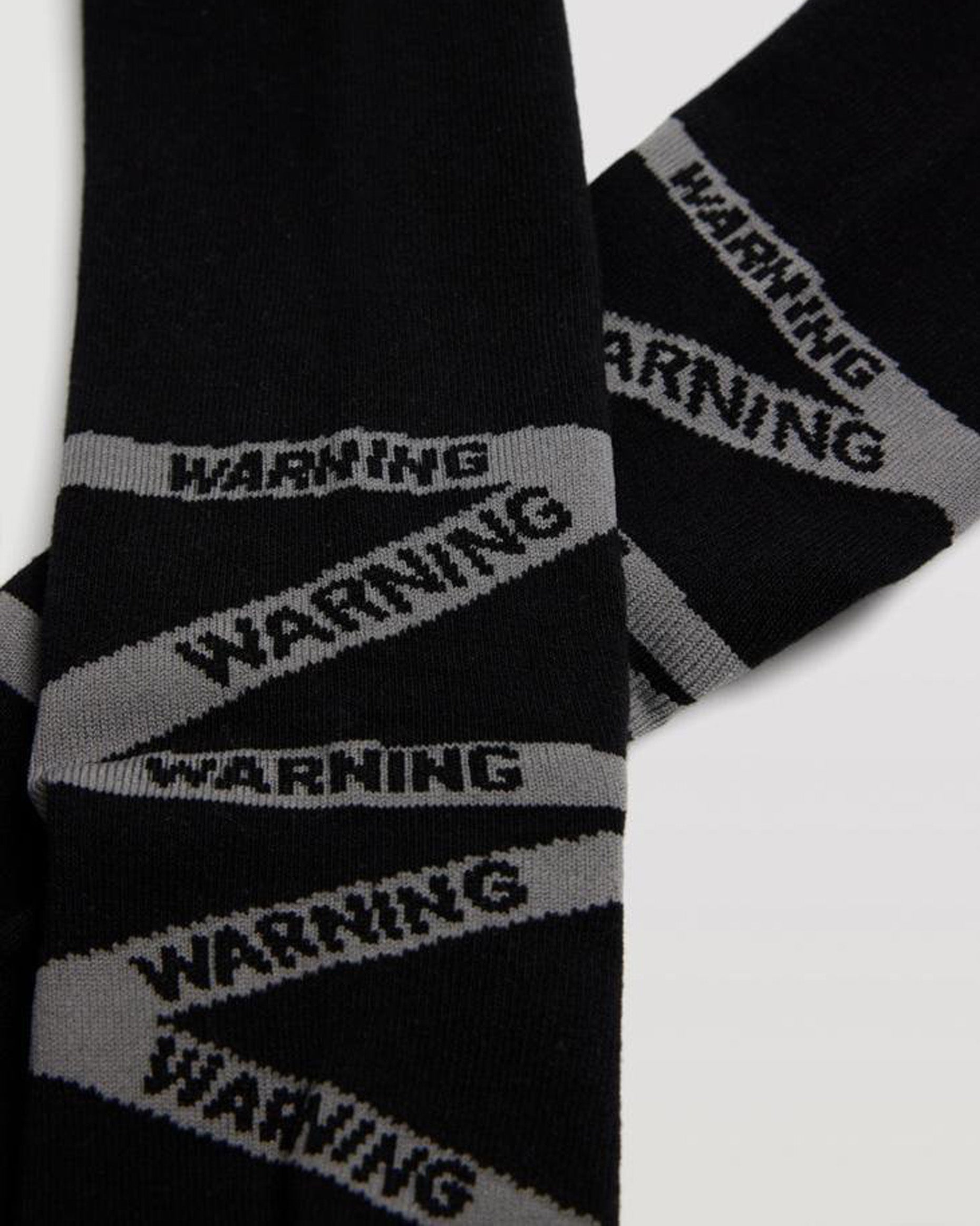Ysabel Mora 22878 Warning Socks - Black cotton mix crew length ankle socks with grey warning tape style pattern wrapping around the foot.