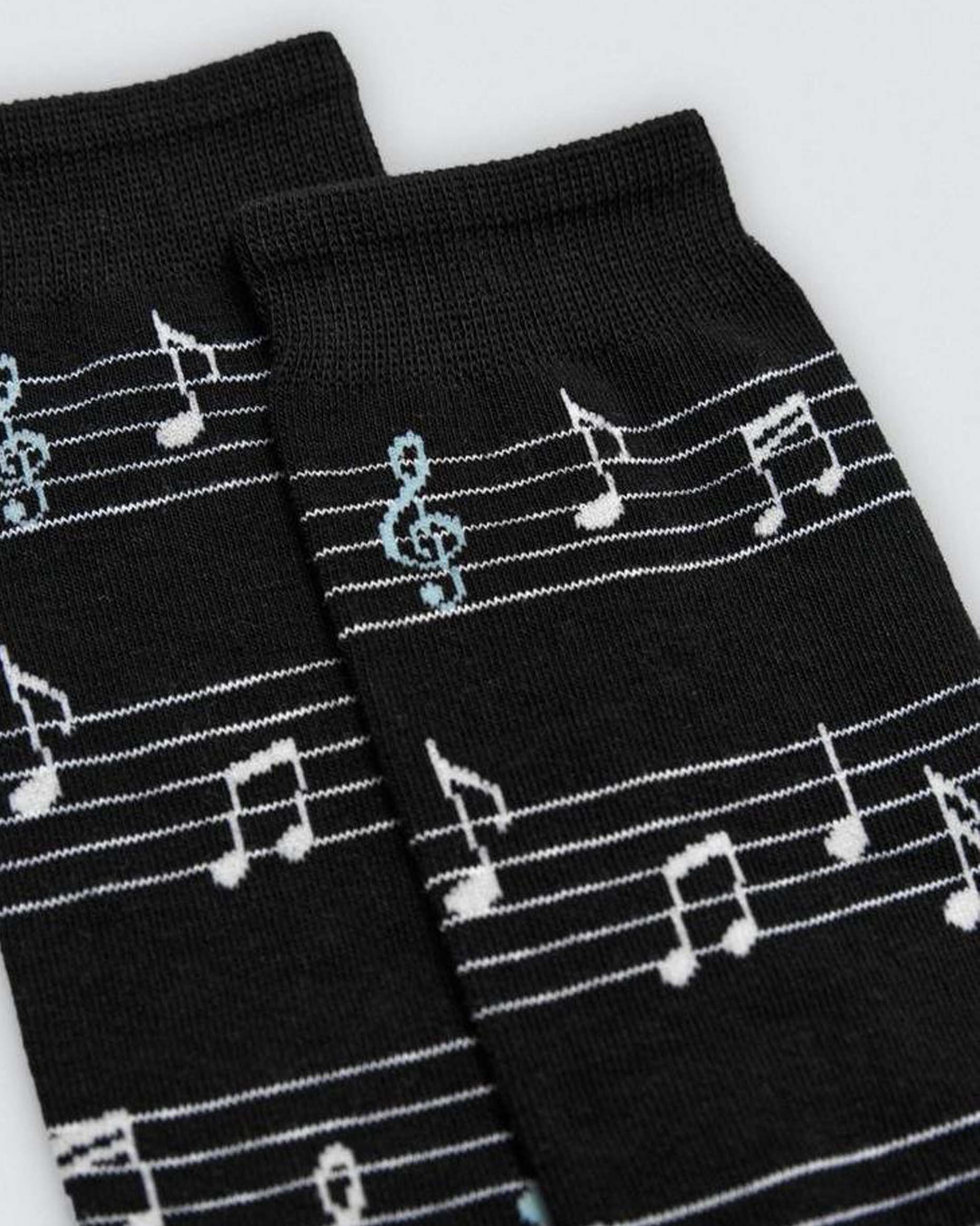 Black socks with white musical note patterns on a light gray background