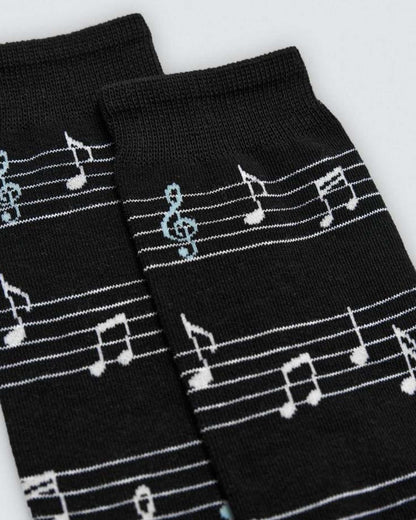 Black socks with white musical note patterns on a light gray background