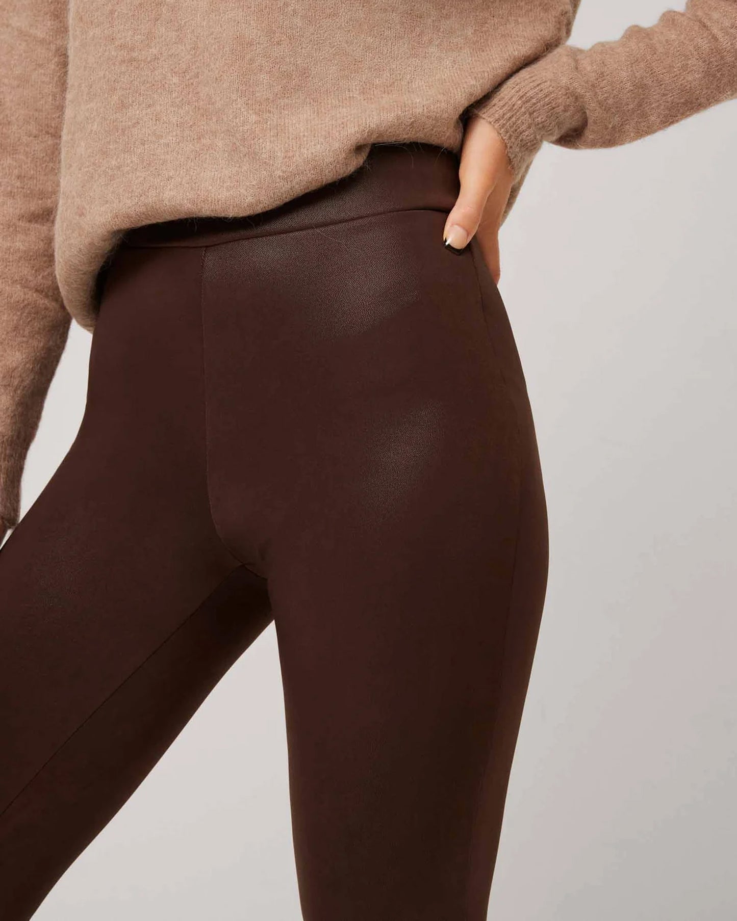 Brown high waisted trouser leggings with faux leather look, worn with beige/camel top..