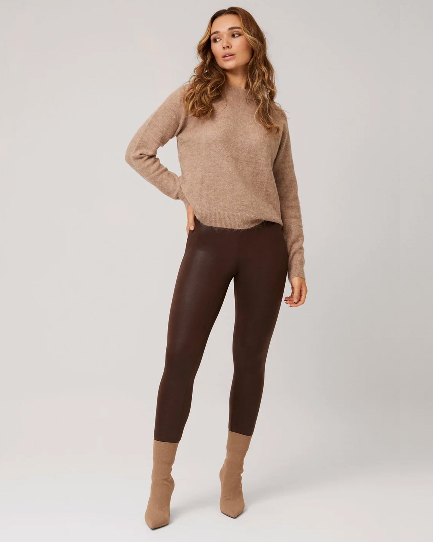 Ysabel Mora 70293 Waxed Thermal Leggings - Woman wearing a beige knitted jumper, brown high waisted thermal trouser leggings with waxed effect print and beige suede high heeled ankle boots.