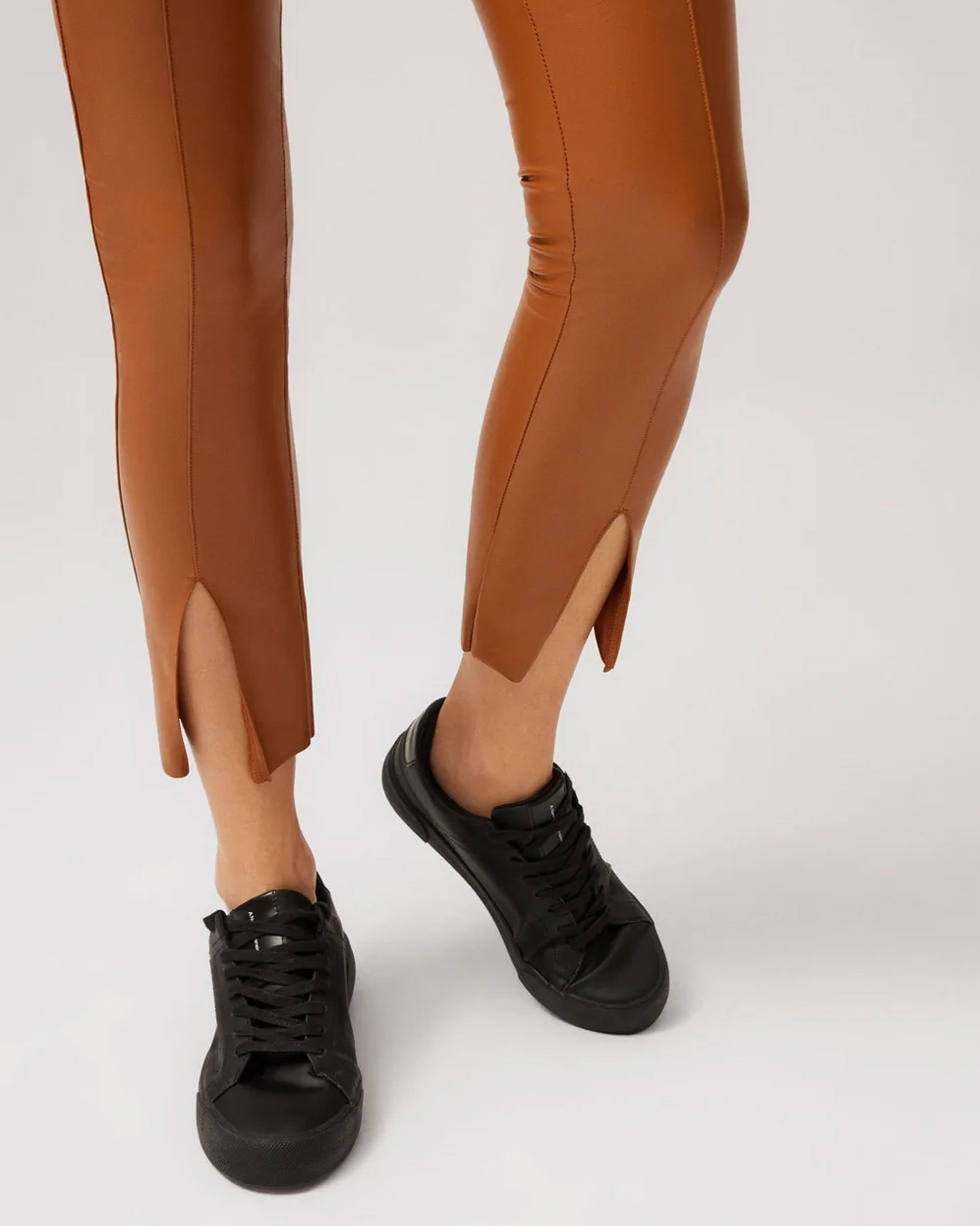 Ysabel Mora 70295 Faux Leather Slit Leggings - Tight fit faux leather thermal camel coloured leggings with a warm plush fleece lining, centre seam down the front, slit opening at the bottom worn with black sneakers.