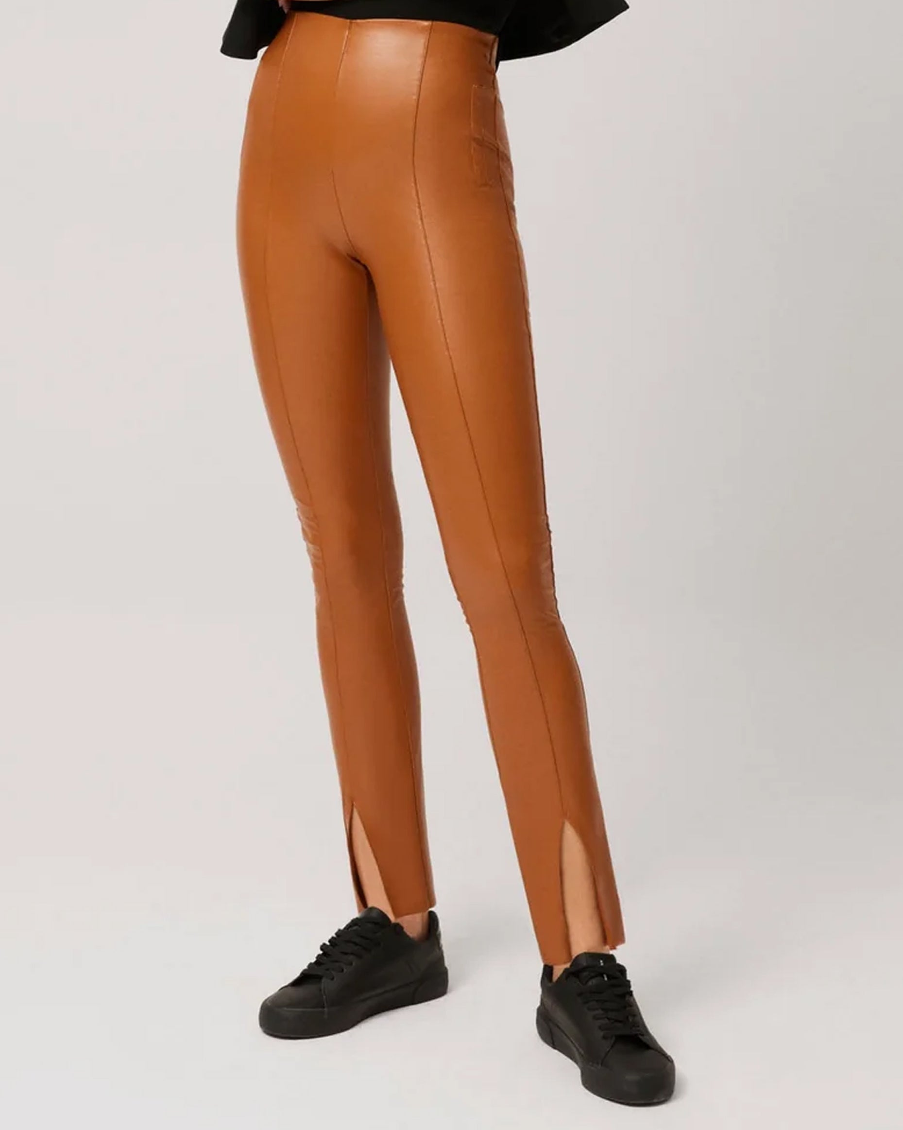 Ysabel Mora 70295 Faux Leather Slit Leggings - Tight fit faux leather thermal camel coloured leggings with a warm plush fleece lining, faux side pocket stitching, centre seam down the front of the leg with a slit opening at the cuff, worn with black sneakers.